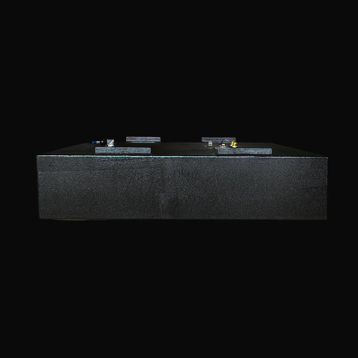 A low-angle straight-on side profile view of a physical, finished black encapsulated 2003 Boston Whaler Outrage 240 OEM replacement marine fuel tank from file image_e6869e.jpg, isolated against a black background. This side-elevation profile highlights the thick, protective, textured black TarGard epoxy coating applied over the heavy-gauge marine-grade 5052-H32 aluminum tank shell to provide maximum resistance against saltwater pitting and bilge cavity moisture. Along the top deck surface, the pre-welded st