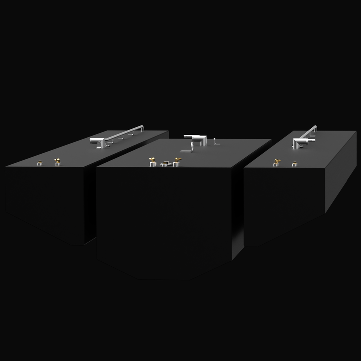 Three black fuel tanks arranged side by side with various metallic fittings, pipes, and handles on top. The tanks have rectangular shapes with angled corners on one end. The background is black