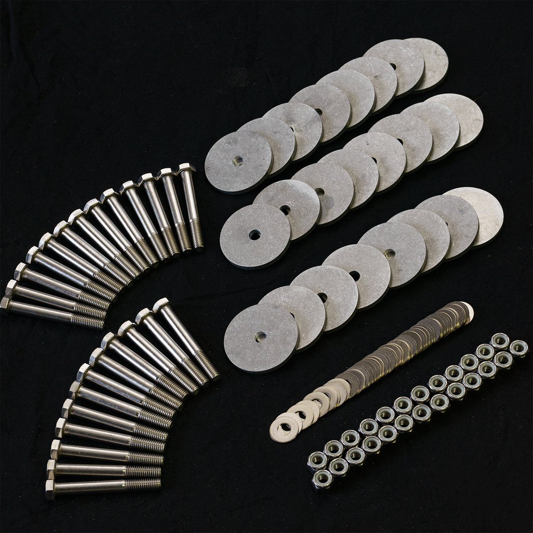 A collection of hardware components for a Standard Apex Single Engine 16° Transom Bracket, including multiple metal washers, bolts, and nuts arranged neatly on a black background