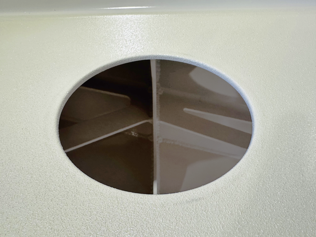 Close-up view of a Mako 261 1990 twin engine high flotation bracket with a circular cutout, showing the interior support structure divided into four sections. The bracket is light-colored with a textured surface