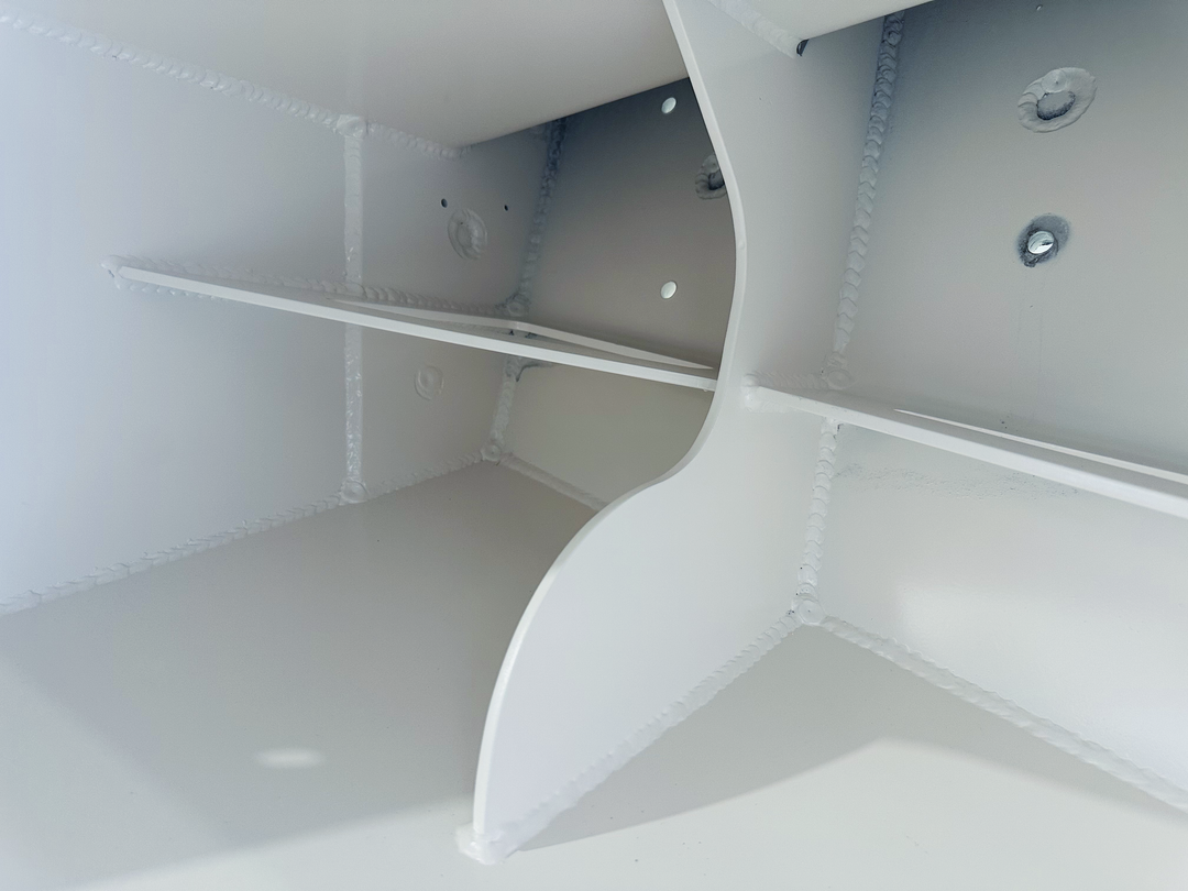 The interior of a white boat compartment with a curved divider and multiple mounting holes, showing a clean, smooth surface with visible welded seams