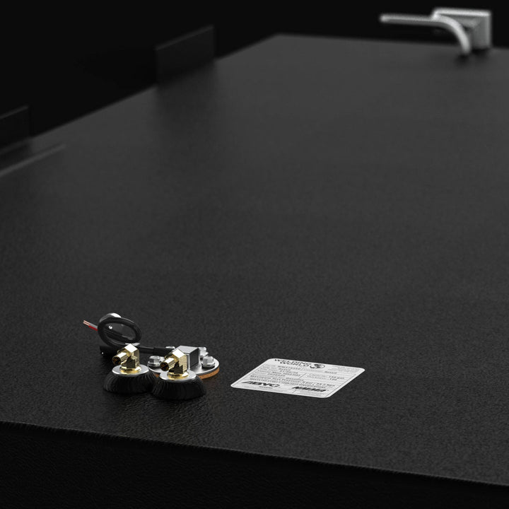 Close-up detail view of the top-mounted fittings on a Regulator 34 CC Sport Fisher replacement fuel tank. The image showcases the precision-machined brass pickups, reed-style fuel sending unit, and official ABYC/NMMA certification label. The rugged texture of the high-build Coal Tar Epoxy coating on heavy-duty .250" marine-grade aluminum is clearly visible, ensuring a guaranteed OEM fit and maximum corrosion resistance for offshore performance.