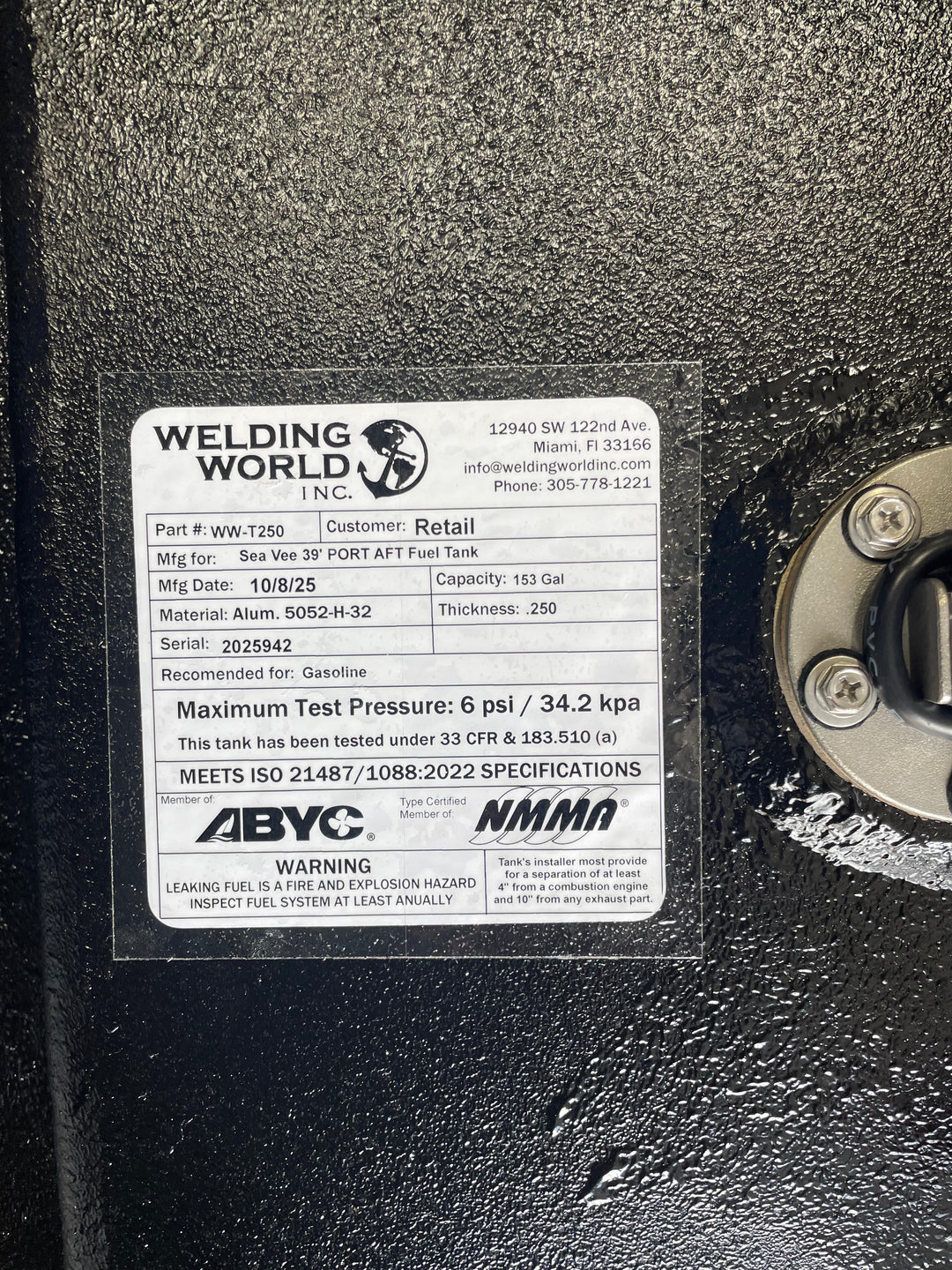 A close-up of a white specification label on a dark textured boat fuel tank. The Welding World Inc. label lists the part as WW-T250, manufactured for a "Sea Vee 39' PORT AFT Fuel Tank," with a 153-gallon capacity.