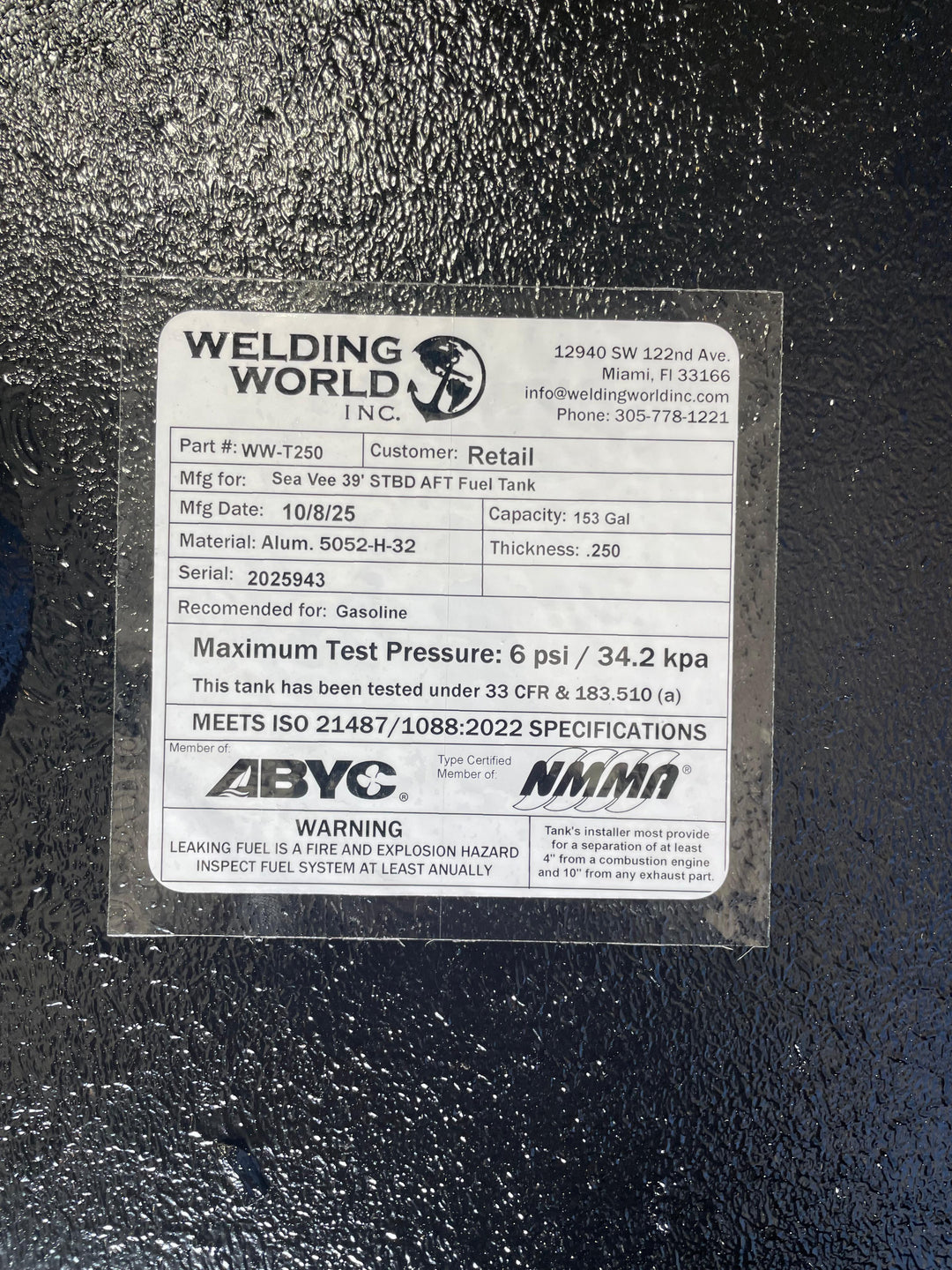 A close-up of a white specification label on a dark textured boat fuel tank. The Welding World Inc. label lists the part as WW-T250, manufactured for a "Sea Vee 39' STBD AFT Fuel Tank," with a 153-gallon capacity.