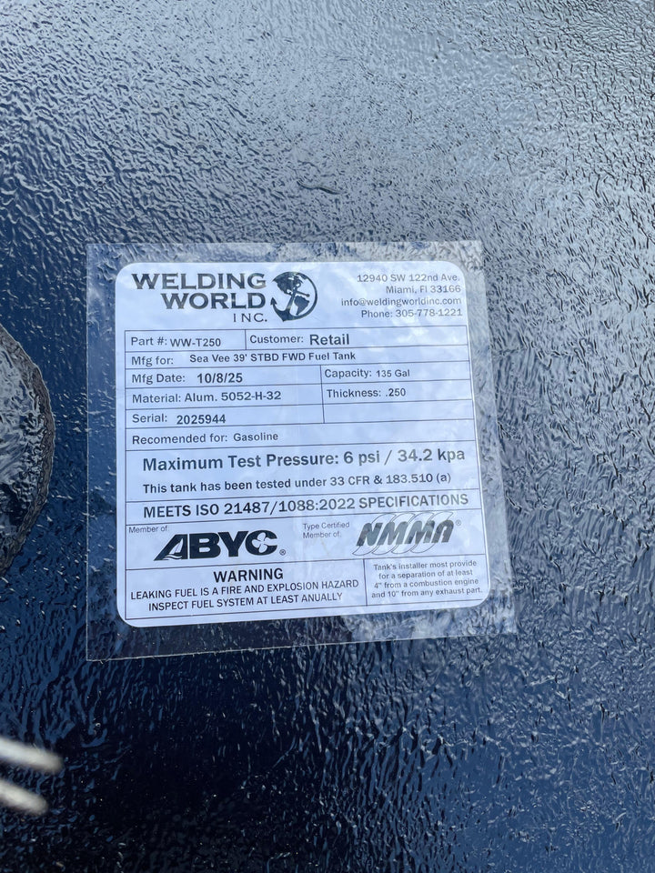 A close-up of a white specification label on a dark textured boat fuel tank. The Welding World Inc. label lists the part as WW-T250, manufactured for a "Sea Vee 39' STBD FWD Fuel Tank," with a 135-gallon capacity.
