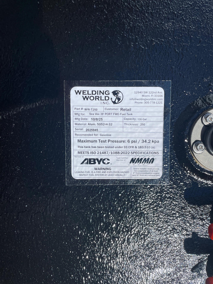 A close-up of a white specification label on a dark textured boat fuel tank. The Welding World Inc. label lists the part as WW-T250, manufactured for a "Sea Vee 39' PORT FWD Fuel Tank," with a 135-gallon capacity.