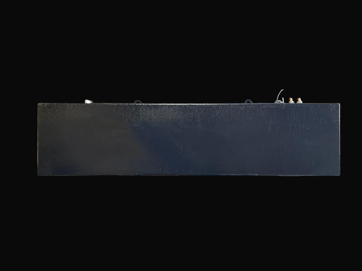 A long side profile photo of a dark, textured boat fuel tank, showing various fittings and D-rings on its top surface, against a black background.