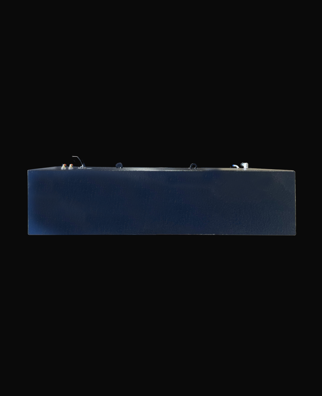 A long side profile photo of a dark, textured boat fuel tank, showing various fittings and D-rings on its top surface, against a black background.