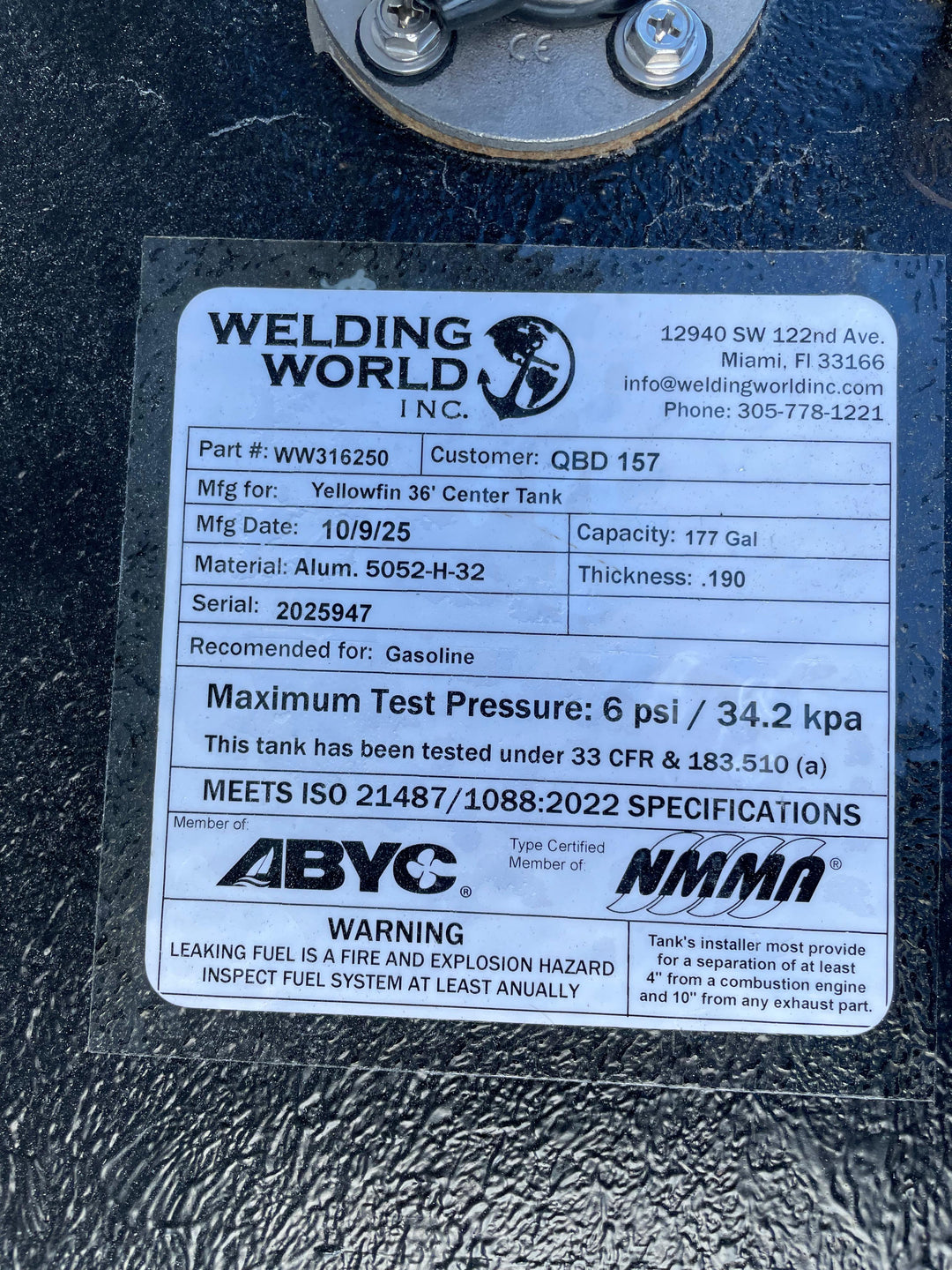 A close-up of a white specification label on a dark textured boat fuel tank. The Welding World Inc. label lists the part as WW316250, manufactured for a Yellowfin 36' Center Tank, with a 177-gallon capacity.
