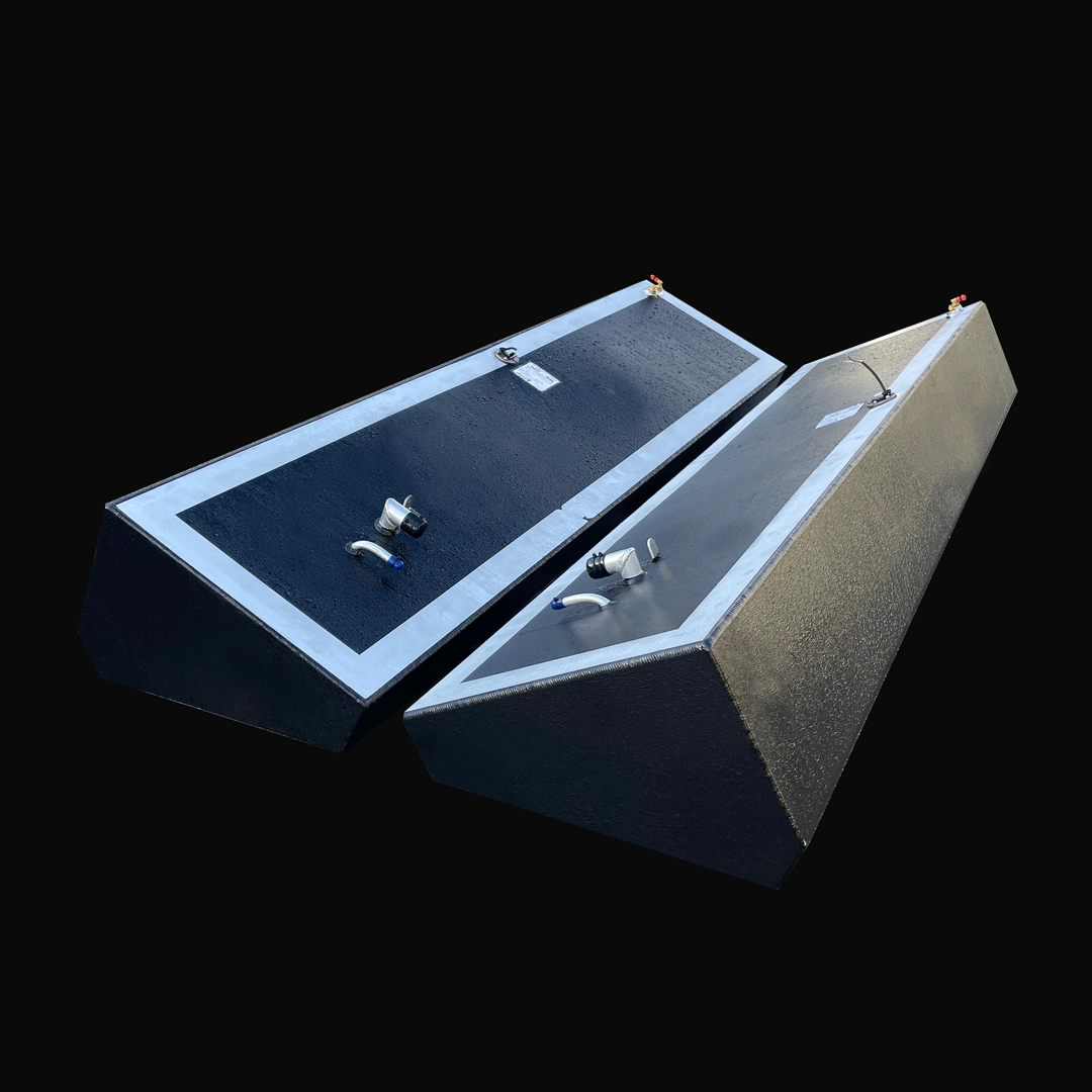 A photo of the Island Runner 104-gallon port and starboard OEM replacement fuel tanks for a 31' 1998 model, showing the pair of long, dark, textured, wedge-shaped tanks angled side-by-side against a black background.