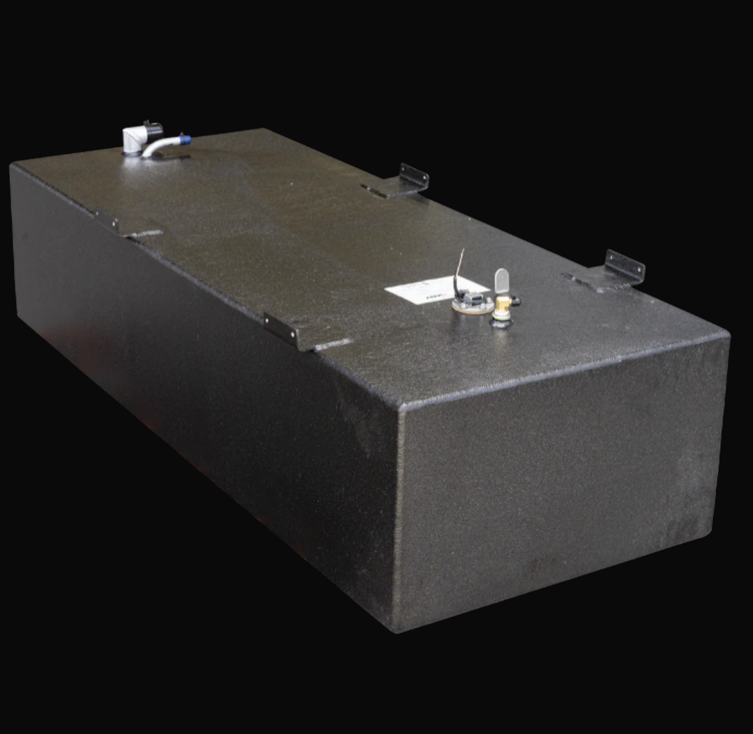 Photograph of an Built to OEM Specs fuel tank for a boat. The tank is rectangular with a textured black finish. It has multiple metal fittings on the top, including a white and blue elbow fitting, a circular gauge, and a sensor with a wire attached. The tank also has black mounting brackets on the top edges. The background is solid black.