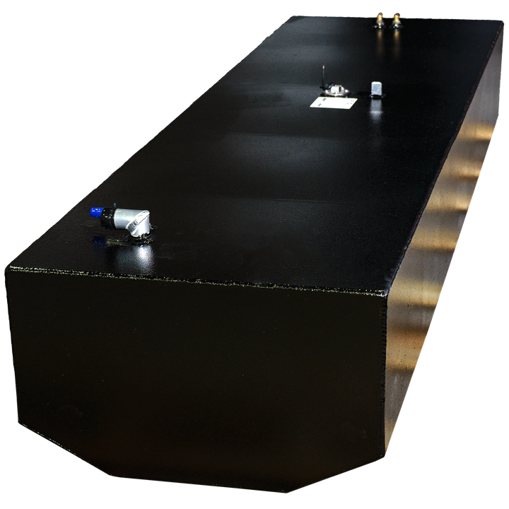 A black, rectangular fuel tank with a textured finish, seen from an elevated angle, showcasing several metal fittings and connections on its top surface. The bottom portion of the tank, particularly on the right side, reveals a metallic, possibly brass or copper, undertone with a reflective sheen. The background is a checkerboard pattern of black and transparent squares