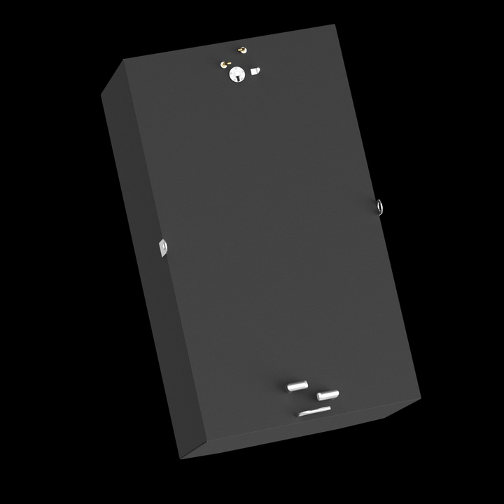 A dark grey, rectangular object, possibly a fuel tank, is shown from a high angle, tilted diagonally against a black background. Its top surface features various metallic fittings, including a round component with a keyhole, small brass-colored knobs, two U-shaped handles, and two silver cylindrical elements alongside a thin, rectangular piece