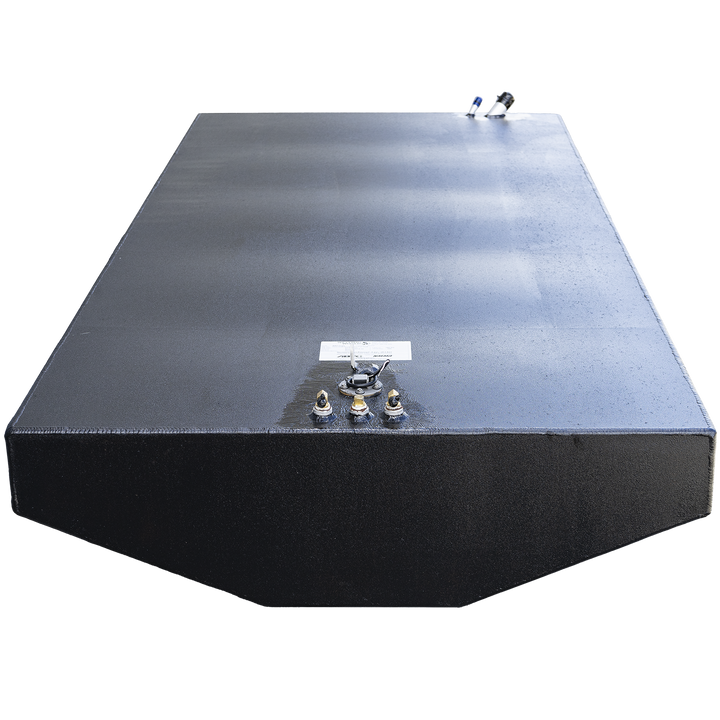 Large rectangular black fuel tank with beveled front edge and straight vertical sides, viewed from the front left corner and looking down the length of the tank. The top surface has several metal fittings clustered near the front left corner and two fittings near the back right corner. The tank shows visible weld seams and has a textured finish. Background is transparent