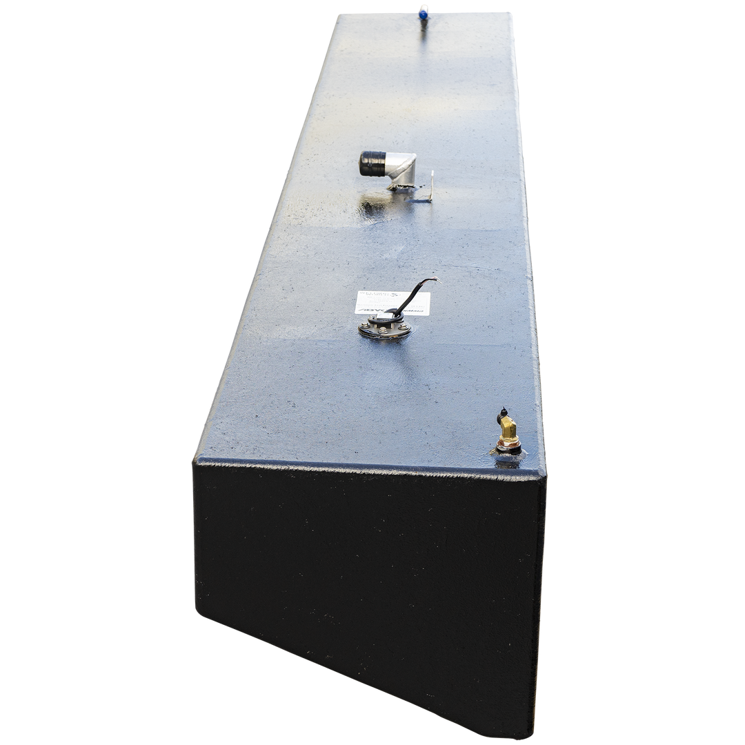 A high-angle, end-on view looking down the entire length of a very long, narrow boat fuel tank, emphasizing its length. The tank has a textured black coating and is set against a checkered background. A series of fittings are aligned down the center of the flat top surface, including a brass corner fitting, a fuel sending unit with a label, an L-shaped valve, and a small blue-tipped fitting at the far end