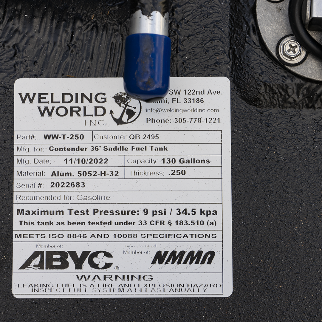 Close-up of a Welding World Inc. label on a black aluminum fuel tank. The label lists part number WW-T-250 for a Contender 36' saddle fuel tank, manufactured on 11/10/2022. Capacity is 130 gallons, made of Aluminum 5052-H-32 with 0.250-inch thickness. Serial number 2022683. Recommended for gasoline. Certified by ABYC and NMMA, meeting ISO 8846 and 10088 specifications. Warning about fire and explosion hazard from leaking fuel. Contact info includes Miami, FL address and phone number 305-778-1221