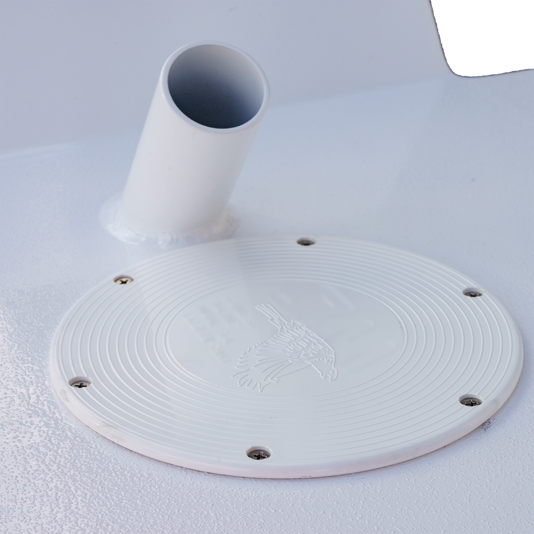 Close-up of a white circular mounting plate with a textured surface featuring a bird emblem, surrounded by four screw holes. A cylindrical pipe is attached to the plate, positioned at an angle. The background is a smooth, white surface