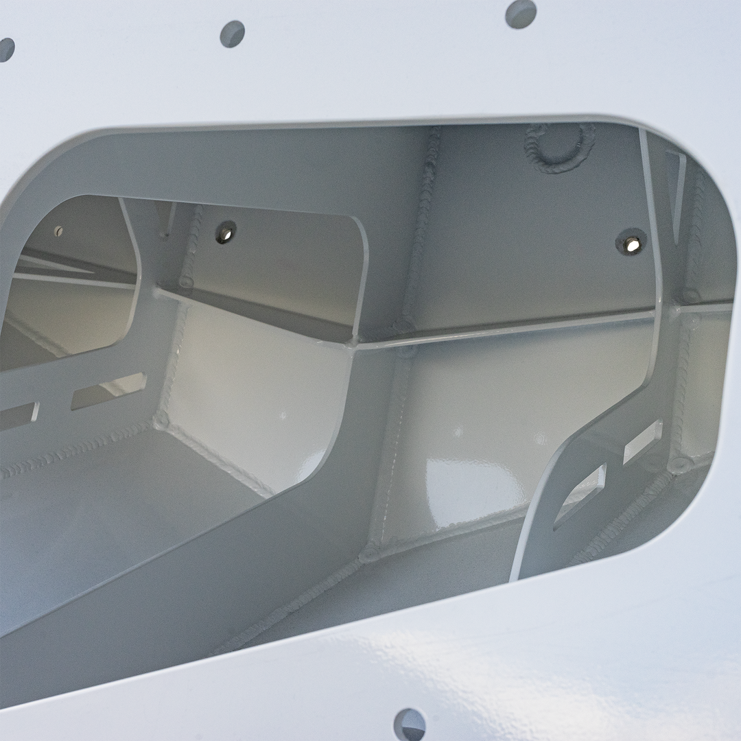 A close-up view of the interior of a white, custom high flotation twin outboard engine bracket, labeled "Mk.2." The interior shows smooth, curved metal surfaces with some visible rivets and mounting holes, designed to support two outboard engines. The image highlights the sturdy construction of the bracket