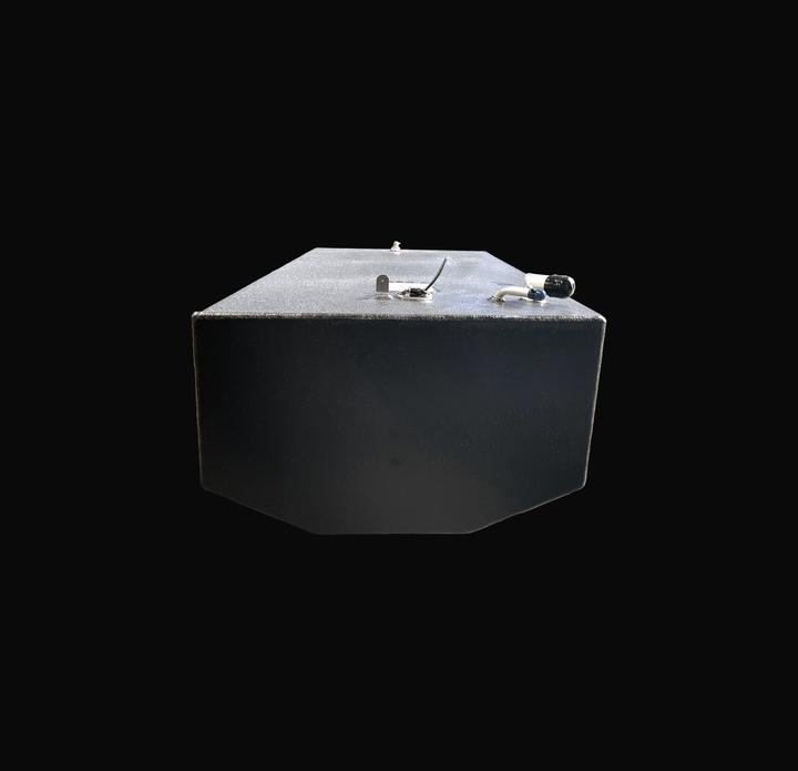 A studio eye-level end view looking down the length of a physical, finished black encapsulated Edgewater 24 OEM replacement marine fuel tank (110 gal) from file image_f68c78.jpg, isolated against a black background. Precision-fabricated from heavy-gauge marine-grade 5052-H32 aluminum, the rectangular body with a tapered bottom hull profile is fully encapsulated in a protective, textured black TarGard epoxy coating to resist severe saltwater pitting and bilge moisture decay. Deck hardware highlights near the