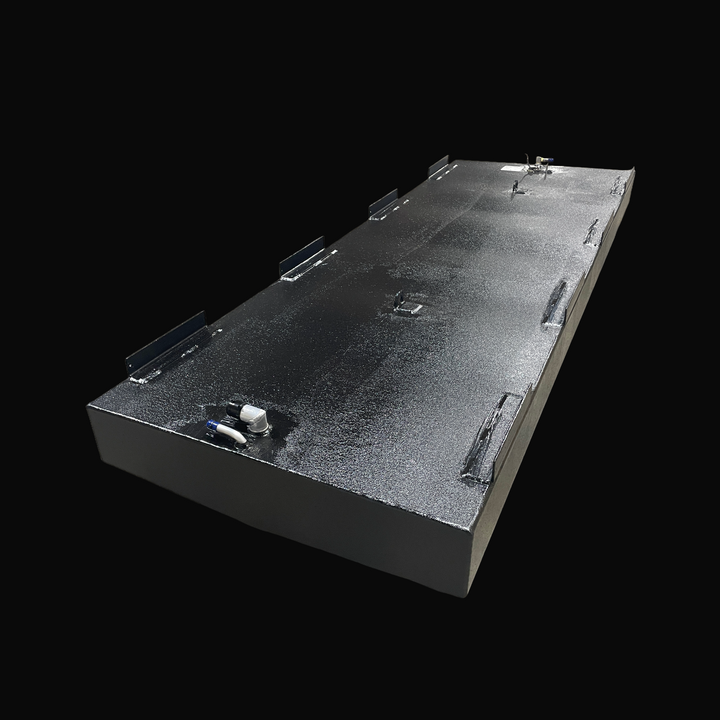 A studio high-angle isometric perspective view displaying the physical, finished black encapsulated Fountain 24 OEM replacement marine fuel tank (130 gal) from file image_c457a4.jpg, isolated against a black background. Precision-fabricated from heavy-gauge .190" marine-grade 5052-H32 aluminum, the elongated hull-contoured body is fully encapsulated in a protective, textured black TarGard epoxy coating to resist severe saltwater pitting and bilge moisture decay. Top deck hardware configuration features heav