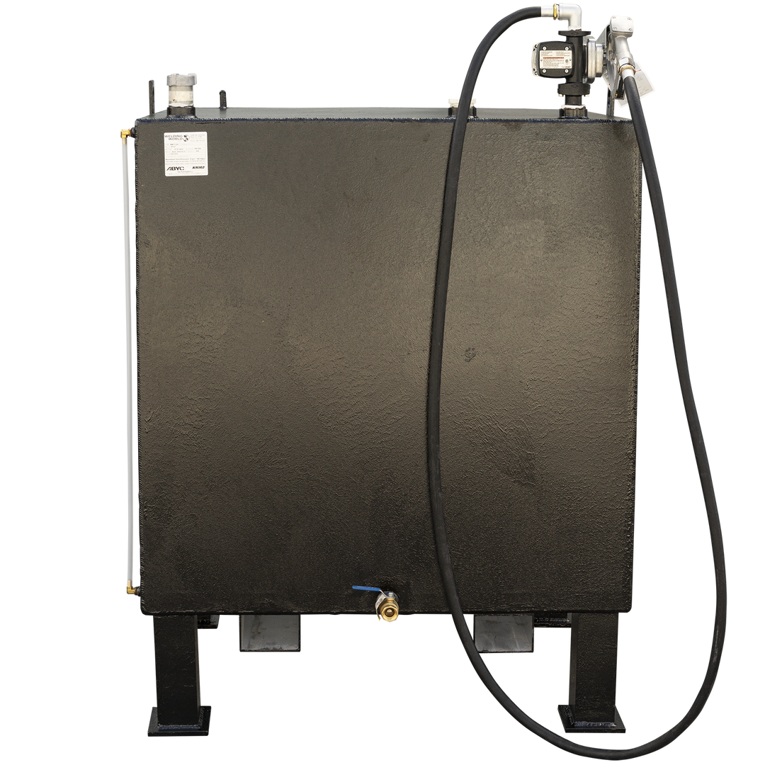 A front view of a black, rectangular fuel tank on black legs, with a fuel pump and nozzle assembly on the top right. A black hose extends from the nozzle, draped over the front of the tank. A white tube with a brass fitting runs vertically along the left side, and a small brass valve with a blue handle is visible near the bottom center. A white label is affixed to the top left of the tank