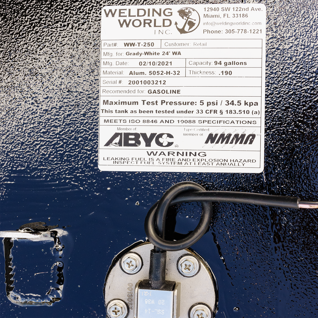 A white product label from Welding World Inc. detailing specifications for a 94-gallon fuel tank for a Grady-White 24' Walkaround 1986, with manufacturing details, material, and safety certifications, positioned above a fuel sender unit with wires