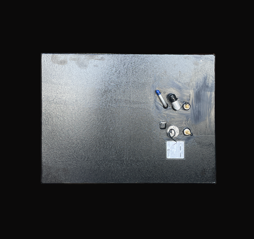 A flat top-down overhead perspective of the Grady White 25 Sailfish auxiliary replacement fuel tank, highlighting the compact rectangular deck arrangement. The entirety of the plate surface features a protective black TarGard epoxy finish over heavy-duty marine-grade aluminum. The cluster of top-deck hardware includes a pre-installed fuel level sending unit with its official ABYC/NMMA certification label, brass fuel line pickups, a fuel fill neck, and dedicated vent fittings. Precision-fabricated by Welding