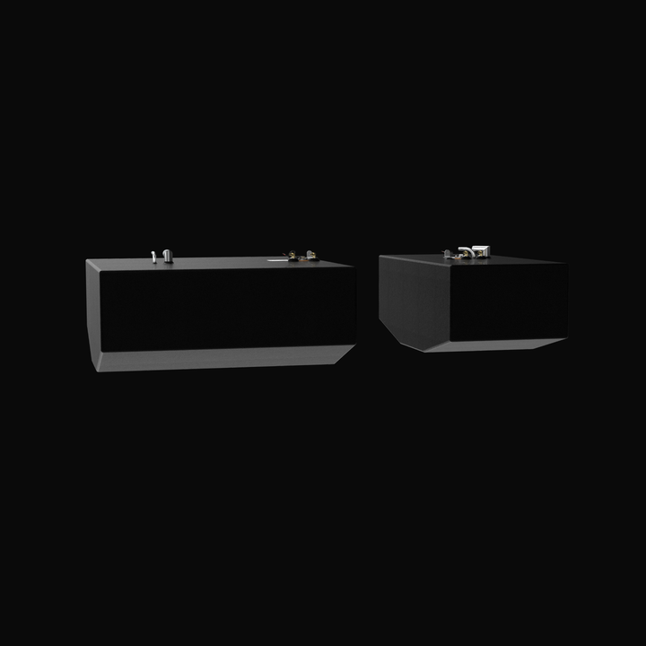 A eye-level studio profile view showing a side-by-side set of physical, finished black encapsulated Grady-White 282 Sailfish Main (140 gal) and Auxiliary (66 gal) OEM replacement marine fuel tanks from file image_f0eda5.png, isolated against a black background. Precision-fabricated from heavy-gauge marine-grade 5052-H32 aluminum, both rectangular tank bodies display custom V-bottom deadrise angles to fit flush inside the vessel's center-cavity bilge compartments. The bodies are fully encapsulated in an anti