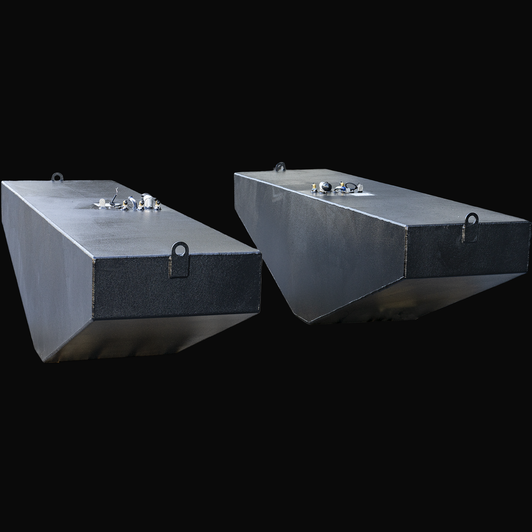 Angled rear view of two black OEM replacement fuel tanks for a 2007 Grady-White 360 Express boat, each with a 185-gallon capacity. Tanks are coated with a textured corrosion-resistant finish and feature sloped bottoms, rear lifting tabs, and top-mounted fittings including sender units and fuel lines. Transparent background