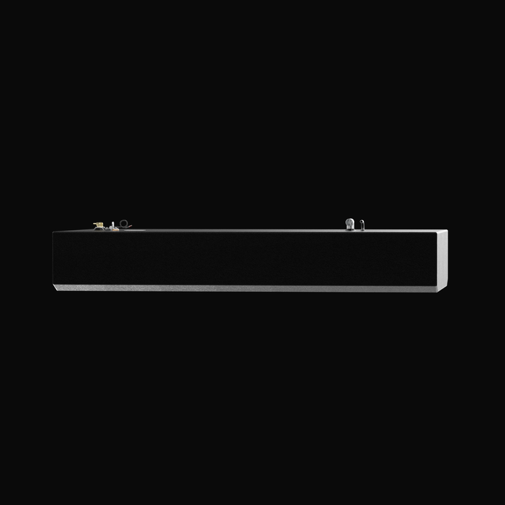 An eye-level studio side profile view of a physical, finished black encapsulated Grady White Freedom 255-257 OEM replacement marine fuel tank (135 gal) from file image_990bc3.png, isolated against a black background. Precision-fabricated from heavy-gauge marine-grade 5052-H32 aluminum, the long rectangular body displays a tapered V-bottom deadrise angle along the lower edge designed to rest flush within the vessel's center-cavity bilge compartment. The body is fully encapsulated in a protective, textured bl