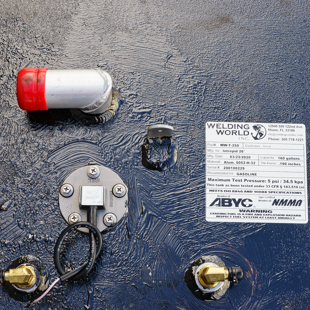Close-up view of an Intrepid 26' OEM replacement belly fuel tank featuring a red fuel fill cap, a fuel gauge, and a label detailing specifications including a capacity of 160 gallons, maximum test pressure, and safety warnings
