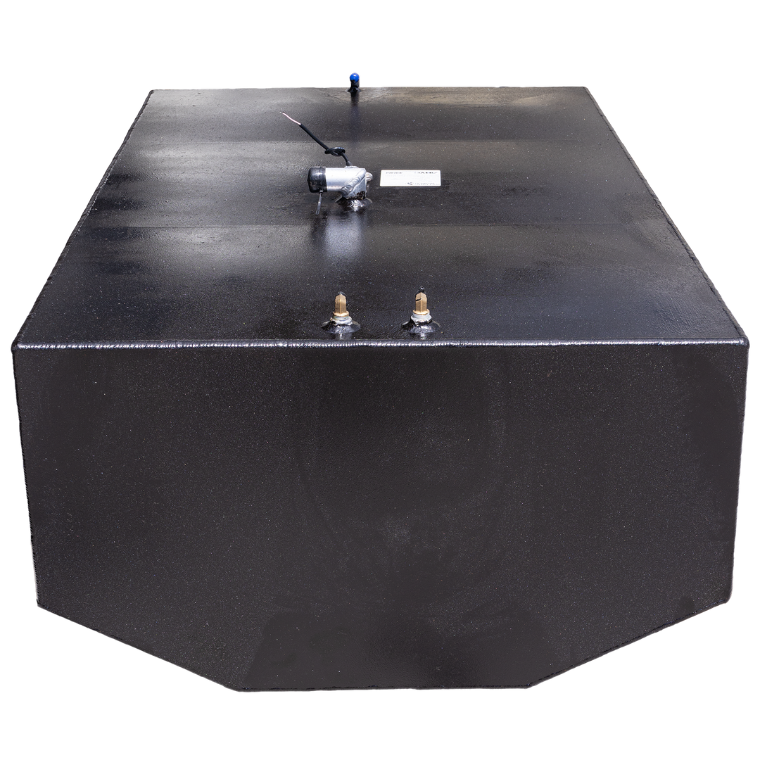 A black, rectangular fuel tank is shown at an angle against a black and grey checkered background. The top surface of the tank features various fittings, including two brass-colored valves and a silver-colored component with wires attached, and a blue-tipped tube in the background