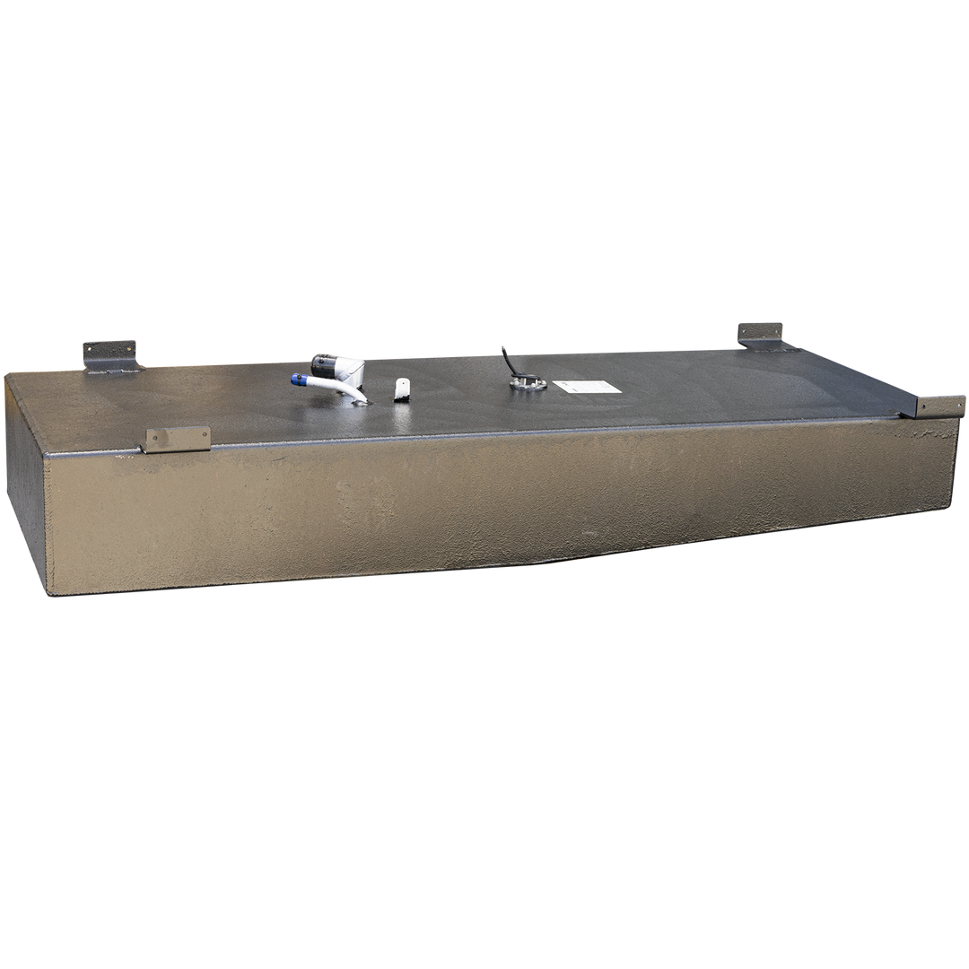 A long, rectangular fuel tank with a black, textured top surface and sand-colored sides, set against a checkered background. The tank has several mounting brackets along its perimeter, and its top surface displays various fittings, including a white and blue hose connection, two small metal posts, a circular gauge with wires, and a small white label. The bottom of the tank appears slightly curved