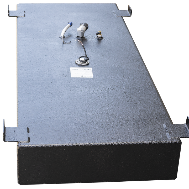 A black, rectangular boat fuel tank with a textured surface, shown from a high angle. It has several mounting brackets along its perimeter. Various fittings and ports are visible on the top surface, including a white and blue hose connection, two small metal posts, a circular gauge with wires, and a small white label