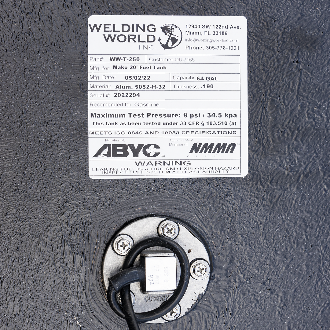 A detailed view of a product label from "Welding World Inc." affixed to a textured black surface. The label provides specifications for a "Mako 20' Fuel Tank" (Part# WW-T-250), indicating a 64-gallon capacity, aluminum material (5052-H-32), and a thickness of .190. It also lists the manufacturing date (05/02/22), serial number (2022294), and states that the tank is recommended for gasoline and tested to 9 psi / 34.5 kpa, meeting ISO 8846 and 10088 specifications