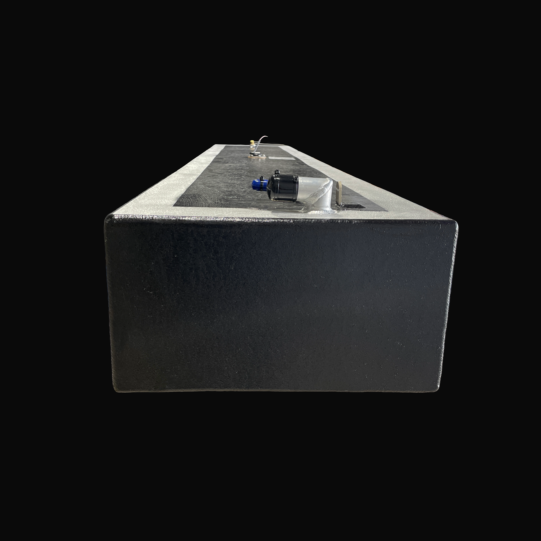 A studio front-facing end perspective view looking down the length of a physical, finished black encapsulated Proline 21 OEM replacement marine fuel tank (84 gal 1994) from file image_15255d.jpg, isolated against a black background. Precision-fabricated from heavy-gauge marine-grade 5052-H32 aluminum, the long rectangular body is fully encapsulated in a protective, textured black TarGard epoxy coating with bare aluminum border margins along the top deck edges. The top deck layout highlights a foreground 90-