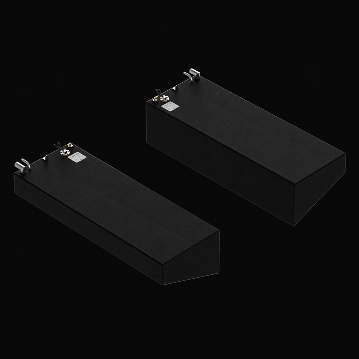 A reversed high-angle isometric perspective view of a black Rinker Fiesta Vee 280 saddle fuel tank 2-tank combo system. This matched pair of port and starboard replacement fuel cells highlights their asymmetric wedge-shaped angled bottoms, precision-engineered by Welding World to align flush against the outboard hull lines of the vessel. Fabricated from heavy-gauge marine-grade 5052-H32 aluminum, both tanks are fully encapsulated in a protective black TarGard epoxy coating to resist bilge corrosion. The top