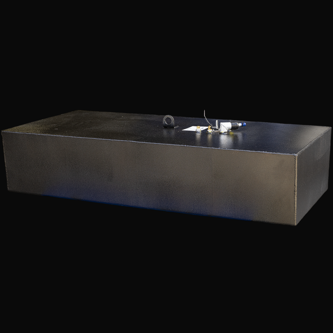 A large black rectangular fuel tank with a flat top surface viewed from a slight left front angle. The tank has multiple fuel system fittings and connectors on top, including capped tubes and wiring. It has a textured black finish with visible weld seams along the edges