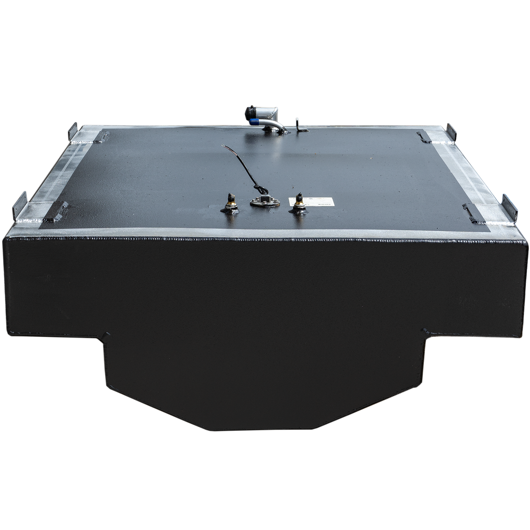 A black, rectangular fuel tank with a textured surface and a metallic frame around its top edge. Various fittings, including a fuel sender and a hose connection, are visible on the top surface. The tank has a stepped cut-out on its bottom left and right side