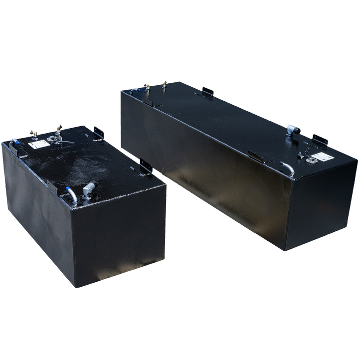 Two rectangular, dark-colored fuel tanks, likely part of a SeaVee 29' 2003 2-Tank Combo 125 & 64 gal. OEM Replacement Fuel Tank Kit, are positioned against a transparent checkerboard background. The tank in the foreground appears smaller, with various metal fittings and connections on its top surface, including brass-colored connectors and silver pipes. The tank in the background is larger and longer, also featuring multiple fittings on its top. Both tanks have a slightly textured finish