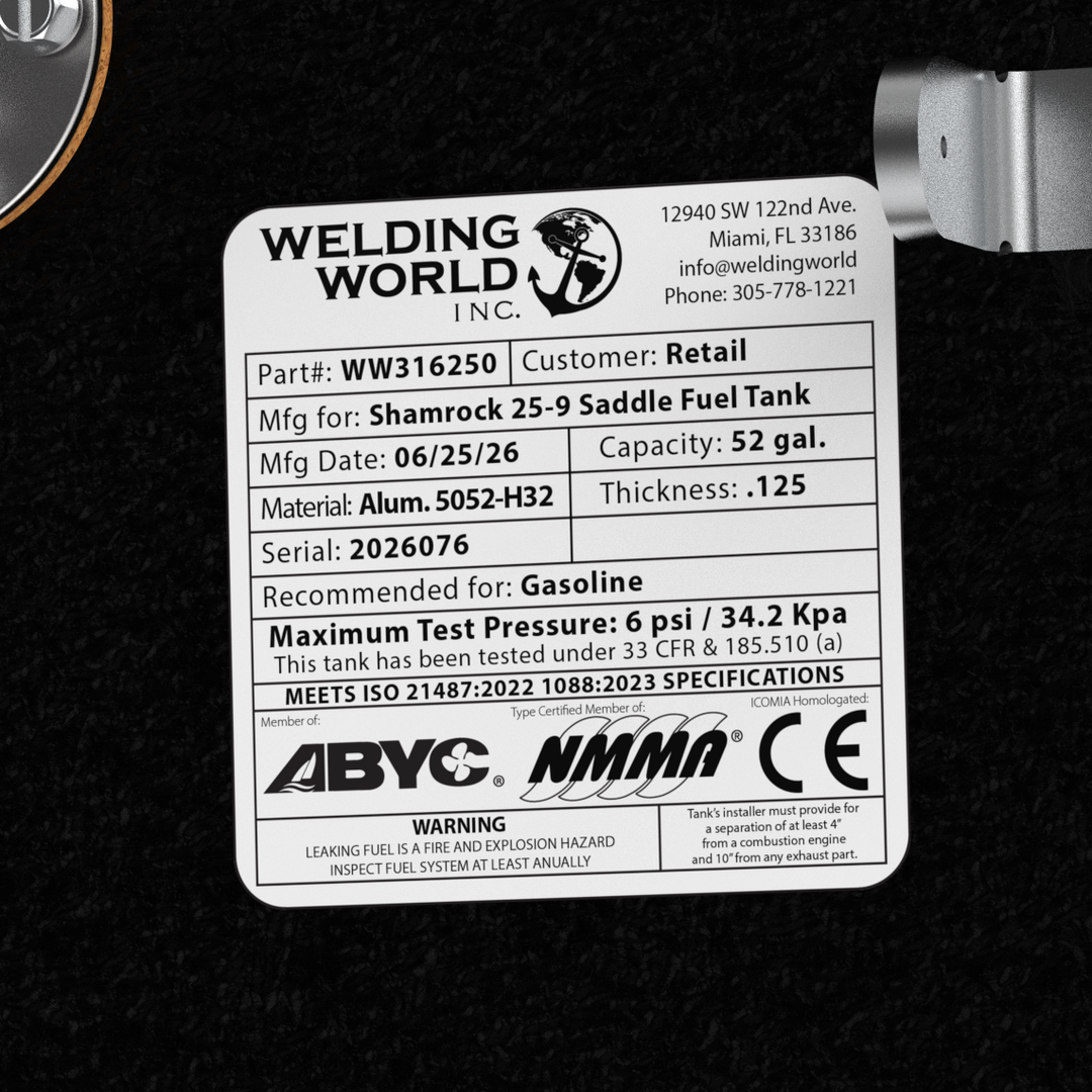 Close-up top-deck hardware layout view of a black Shamrock 25-9 Saddle replacement marine fuel tank from file image_73567d.jpg. The image highlights a central manufacturer specification data placard listing part number WW316250, serial number 2026076, and a manufacture date of 06/25/26. Fabricated from marine-grade 5052-H32 aluminum with a thickness of .125, the 52 gal. capacity outboard tank body is fully encapsulated in a protective, textured black TarGard epoxy coating. The data label sits perfectly bala