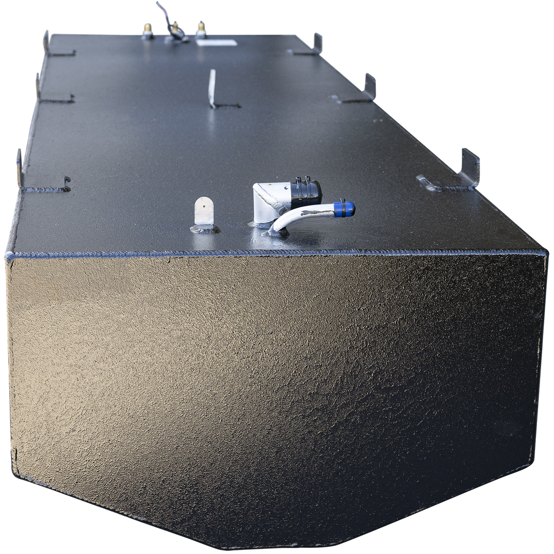 Large black metal fuel tank with visible weld seams and several mounting tabs along the top and side edges. The tank has a rounded front edge and multiple metal fittings on the top surface, including a curved white pipe with a blue cap and a black connector. The background is transparent, focusing on the tank from an angled front perspective