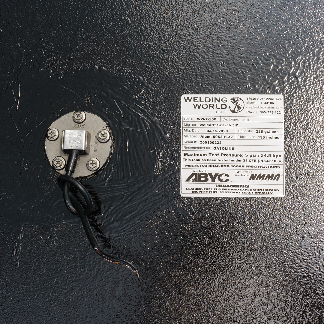 Close-up of a SeaVee 26' 2-Tank Combo fuel tank kit, featuring a label from Welding World with specifications, including part number, model, and maximum test pressure, mounted on a black tank surface
