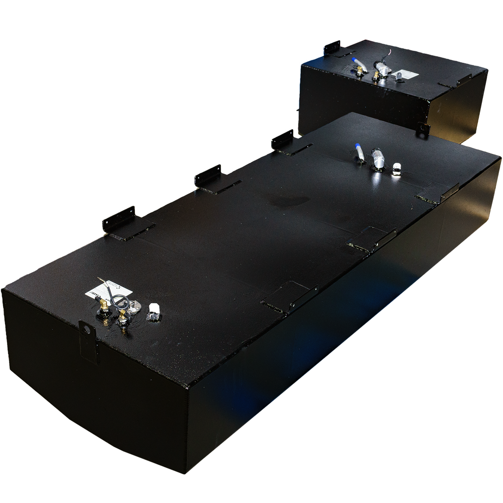 An elevated view of two black rectangular fuel tanks, part of a Mako 252 - 1999 OEM Replacement Belly Fuel Tank Combo Kit, designed to hold 142 and 51 gallons respectively. The tanks have a slightly textured finish and feature various metallic fittings and connections on their top surfaces. The tanks are placed on a black and grey checkered surface, with light reflecting off their sides
